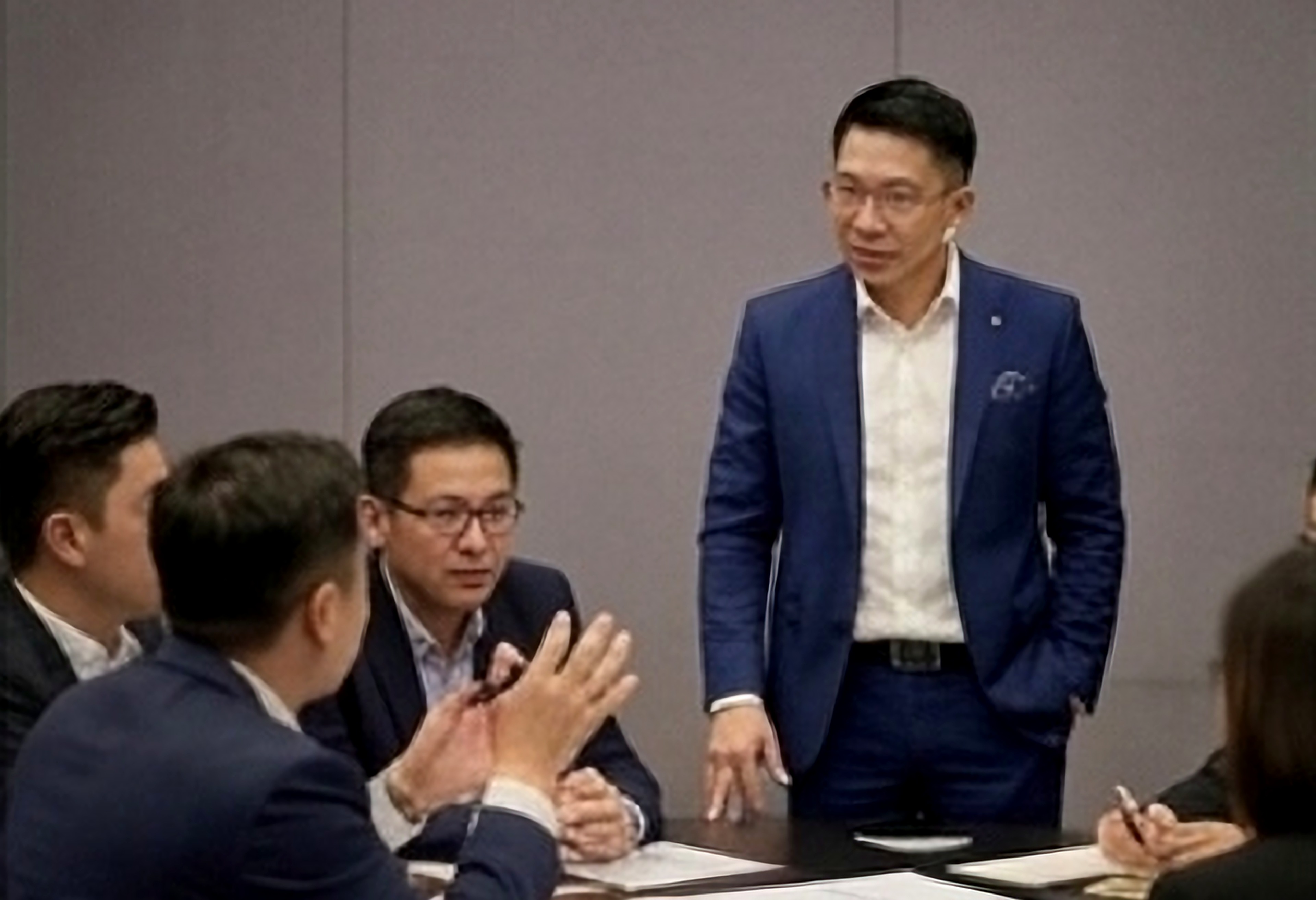 JC Leung facilitating Corporate Changemaker programme — group discussion in modern office